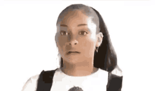 a woman with a ponytail and a surprised look on her face is standing in front of a white background .