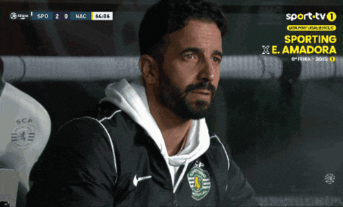 a man with a beard is watching a soccer game on sporttv