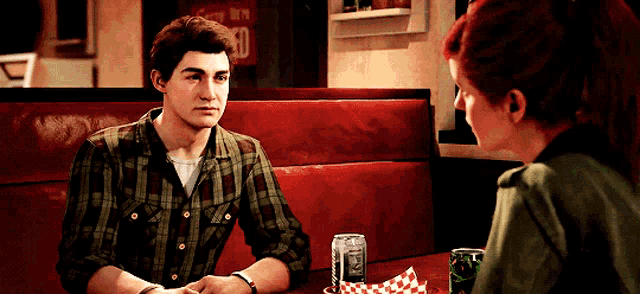 a man and a woman are sitting at a table with a can of diet coke on it