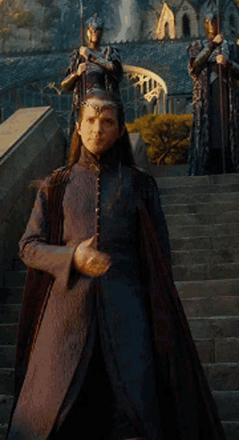 a woman in a long dress is standing on stairs