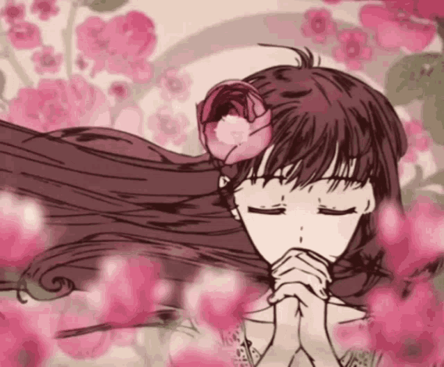 a girl with a flower in her hair is praying with her eyes closed