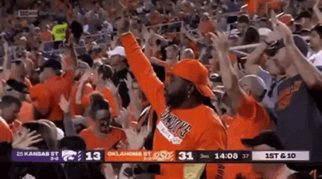 a man wearing an oklahoma state shirt stands in the crowd