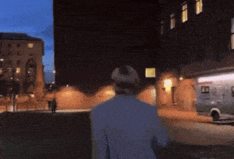 a man walking down a street with an ambulance parked in front of him