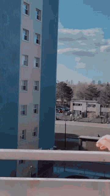 a balcony with a view of a blue building and a city