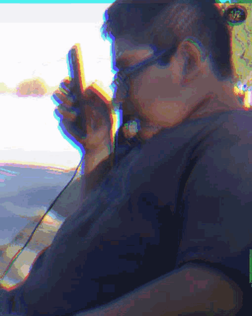 a pixelated image of a man wearing headphones holding a cell phone