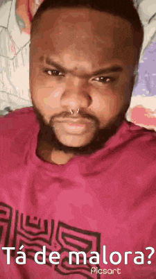 a man with a beard and a nose ring is making a funny face .