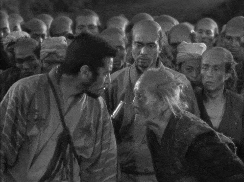 two men in kimonos are laughing and one has a sword in his hand