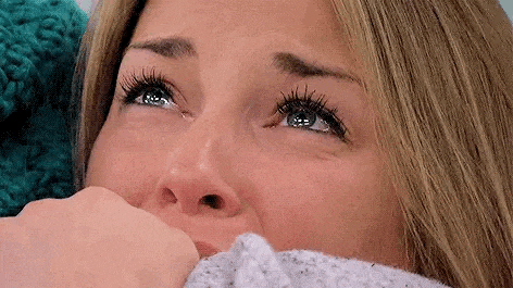 a woman is crying with a tear coming out of her eye .