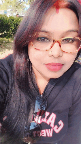 a woman wearing glasses and a black shirt that says " alia j " on it