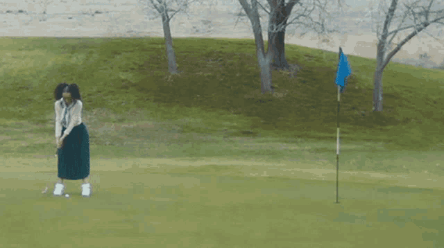 a woman in a green skirt is playing golf