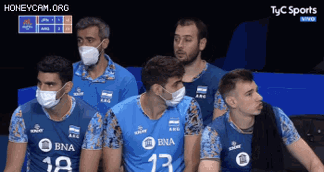 a group of volleyball players wearing face masks and jerseys with the number 13