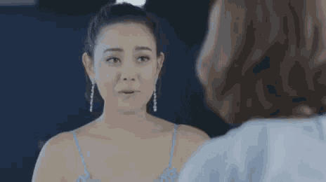 a woman is looking at herself in the mirror and crying .