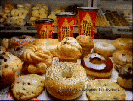 a variety of donuts and muffins are displayed in a store