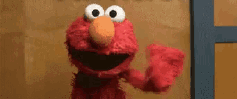 elmo from sesame street is waving his hand in front of a door .