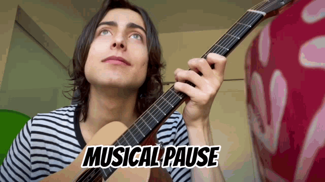 a young man playing a guitar with the words musical pause behind him