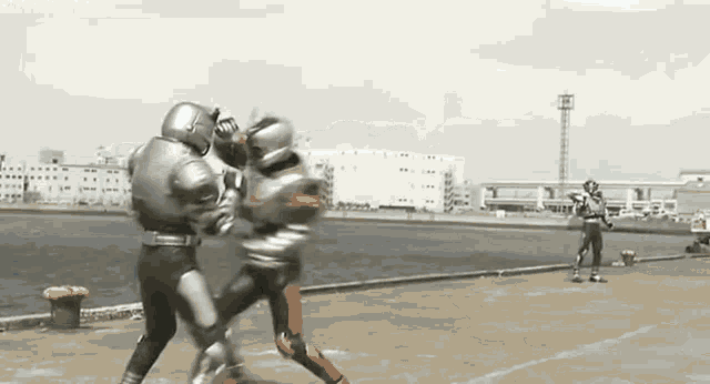 a group of superheros are fighting each other on a roof .