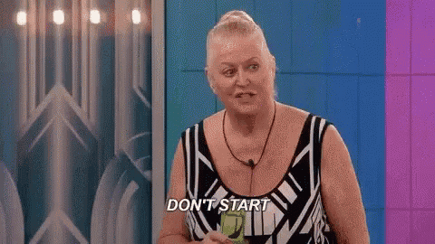 a woman in a black and white dress is standing in front of a wall and says `` don 't start '' .