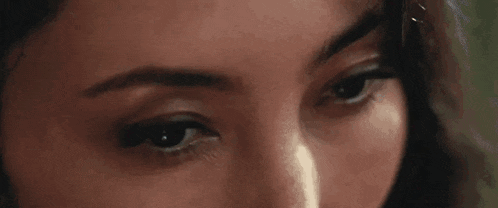 a close up of a woman 's eyes with a tear coming out of her nose .