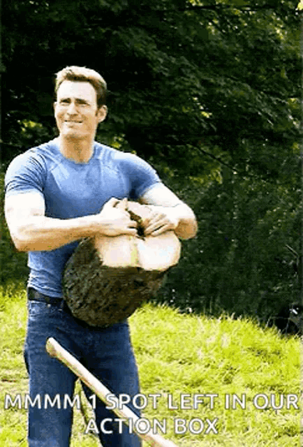 a man in a blue shirt is holding a log in his hands .