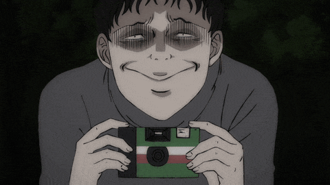 a man is holding a green camera with a red and white stripe