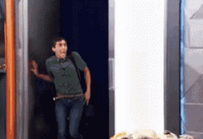 a man in a green shirt is running out of a doorway