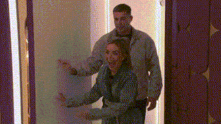 a man and woman are standing next to each other in a room .