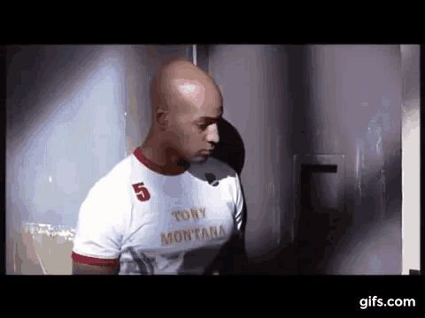 a bald man wearing a white shirt that says tony montana