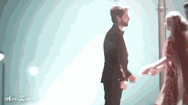 a man in a suit stands next to a woman in a red dress and the words ashizinity are visible in the corner