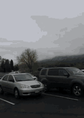 several cars are parked in a parking lot including a silver car with a license plate that says ' nc '