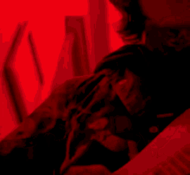 a close up of a person 's face with a red background