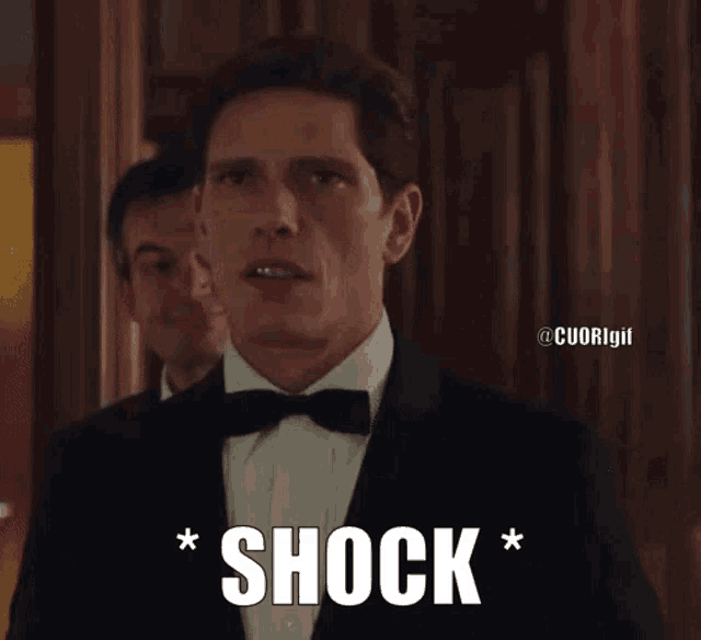 a man in a tuxedo and bow tie says " shock "