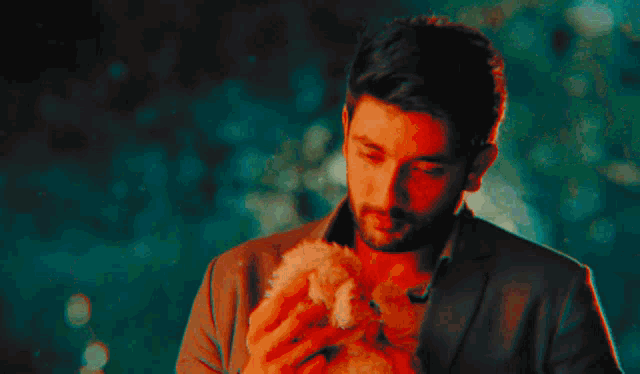a man holding a puppy next to a car with the date november 29th on the back