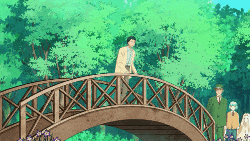 a group of people standing on a wooden bridge in a forest