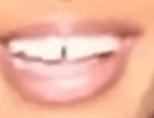 a close up of a woman 's mouth with white teeth and a smile .