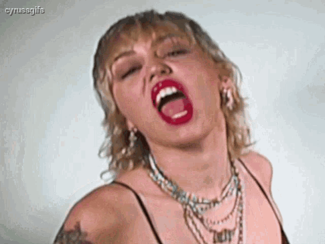 a close up of a woman making a funny face with her mouth open .