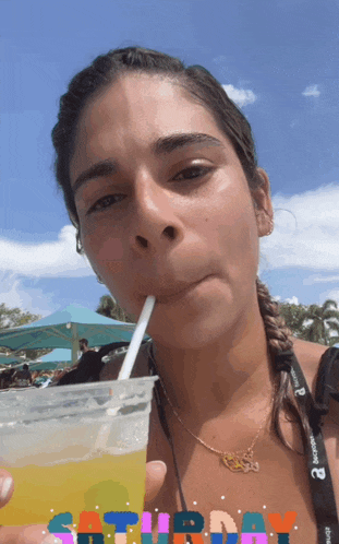 a woman drinking through a straw with saturday written on the bottom