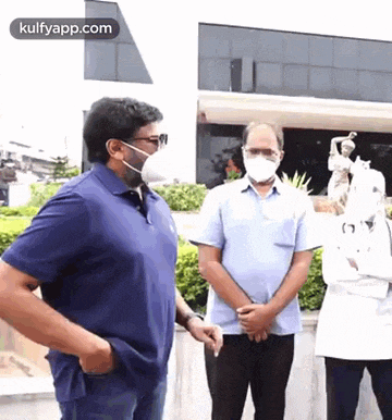 a man wearing a mask is standing next to another man .