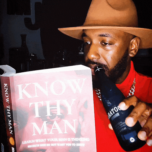 a man is drinking from a bottle while reading a book titled know thy man