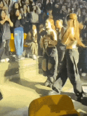 a group of women are dancing in front of a crowd at a concert