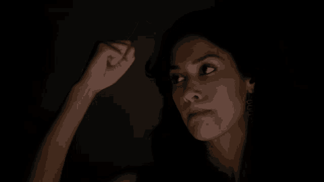 a woman with her eyes closed and her hand on her head