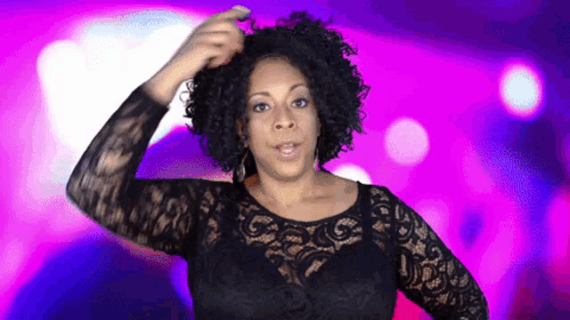 a woman with curly hair is wearing a black lace dress