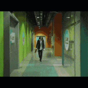 a person walking down a hallway with a sign on the wall that says ' a '
