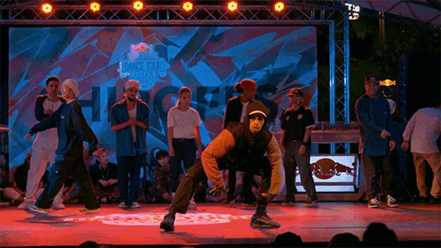 a group of people are performing in front of a screen that says red bull on it