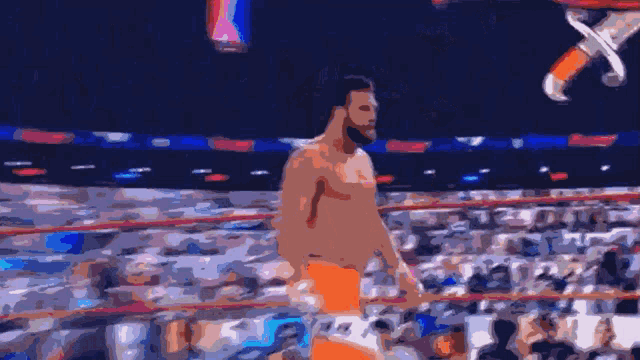a man without a shirt is walking in a ring