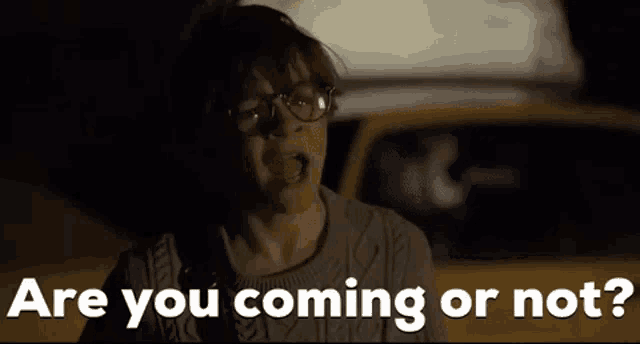 a young boy wearing glasses is standing in front of a yellow taxi and asking are you coming or not ?