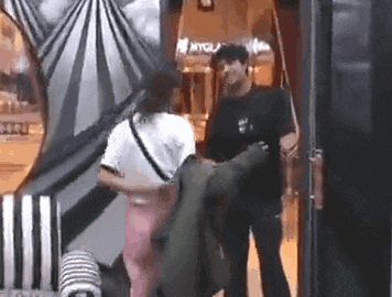 a man and a woman are standing next to each other in a room in a shopping mall .