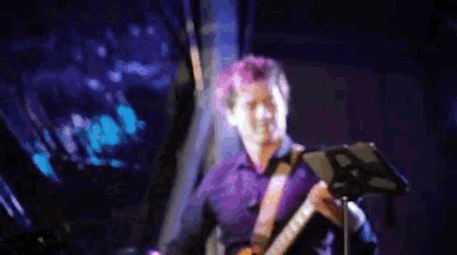 a blurry image of a man playing a guitar