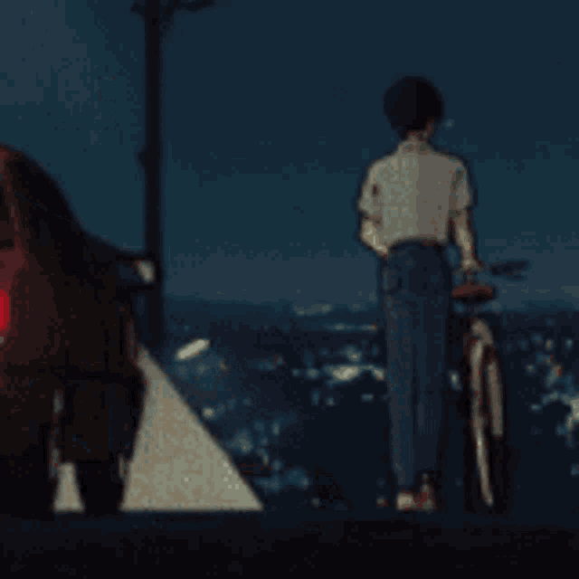 a man standing next to a bicycle in front of a car