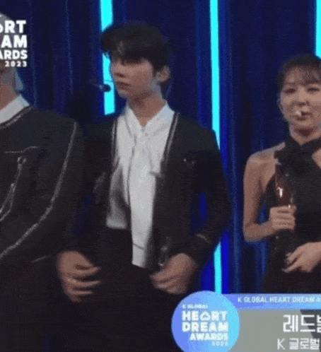a man and a woman are on a stage at the heart dream awards 2020