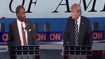 two men are standing in front of a cnn sign